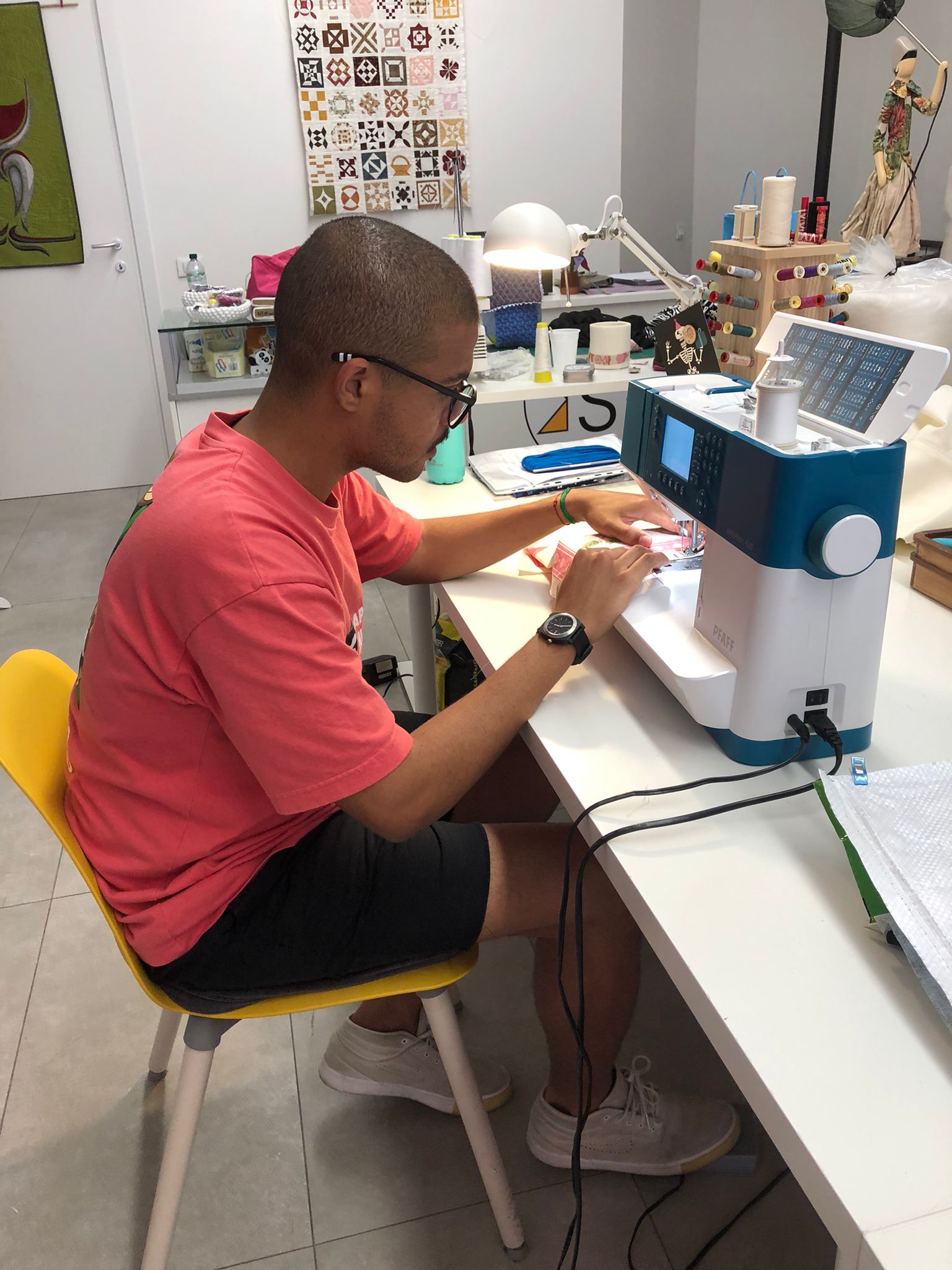 Renan working at a sewing machine in an Italian studio